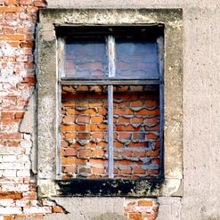 Vermauertes Fenster in alter Backsteinwand.