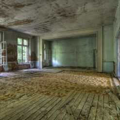 Verlassener Raum mit Sand und alten Fenstern.